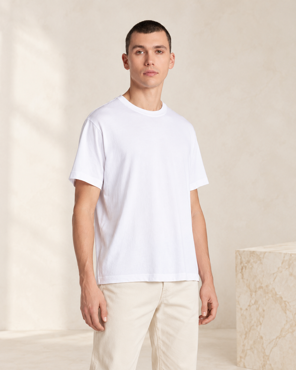 Aria white oversized T-shirt — model styling with cream trousers