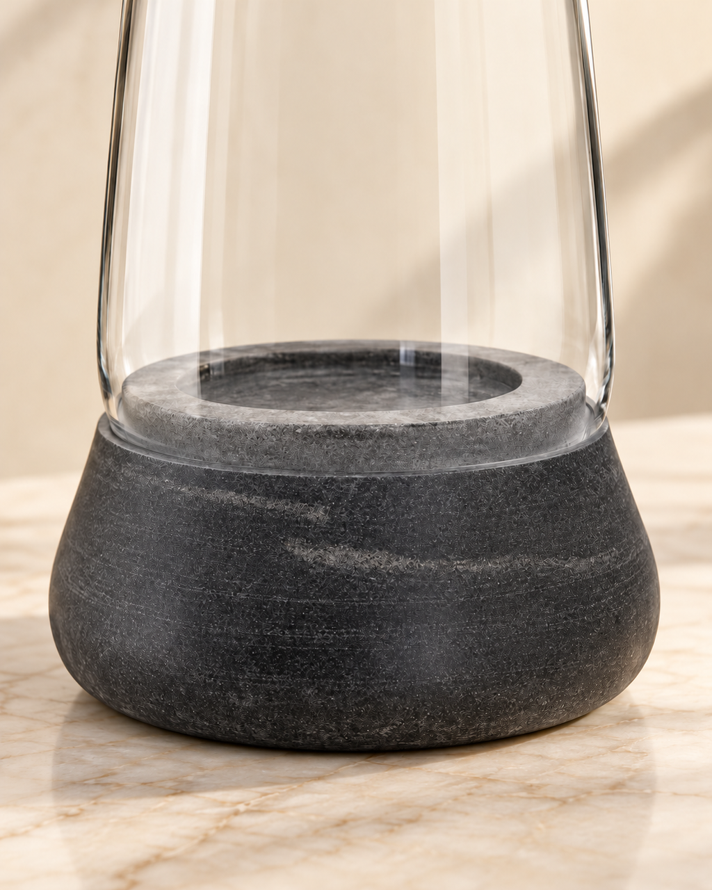 Close-up of Kira grey marble base, recessed ring and clear glass on cream marble