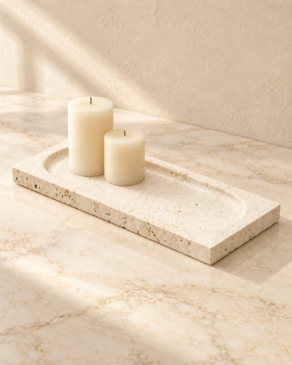 Tibor travertine tray styled with cream candles on cream marble; candles not included